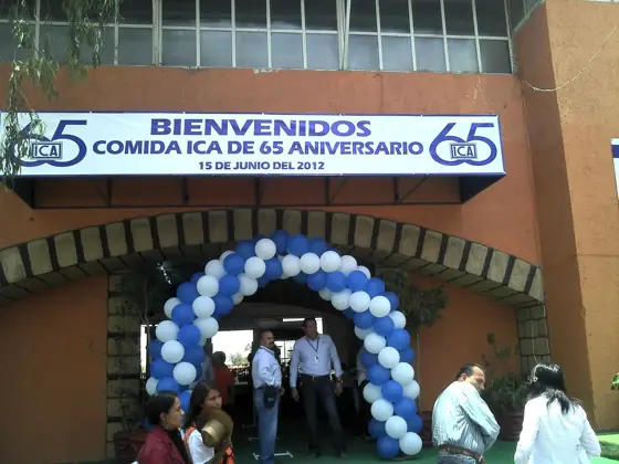 Entrada del lienzo charro con arco de globos azules y blancos y asistentes