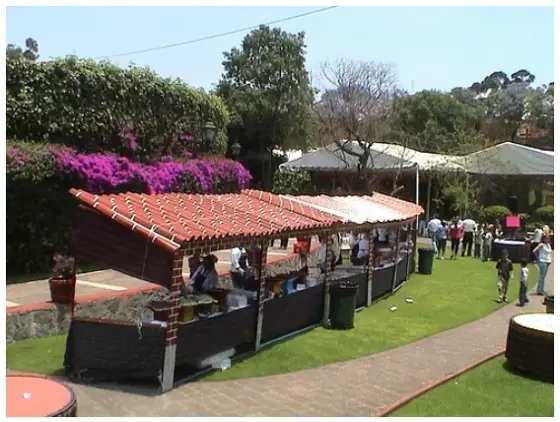 Barra de comida con techo de teja y jardín en un evento