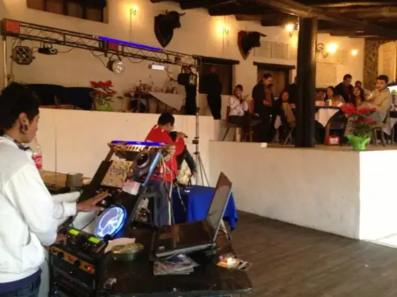DJ con equipo de sonido en un salón con decoración charra