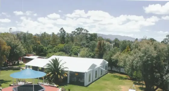 Vista aérea del jardín con kiosco, carpa blanca y área de juegos