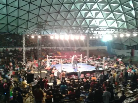 Ring de boxeo montado en un recinto cubierto con público en las gradas