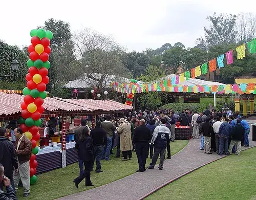 Fiesta mexicana en jardín con papel picado y globos