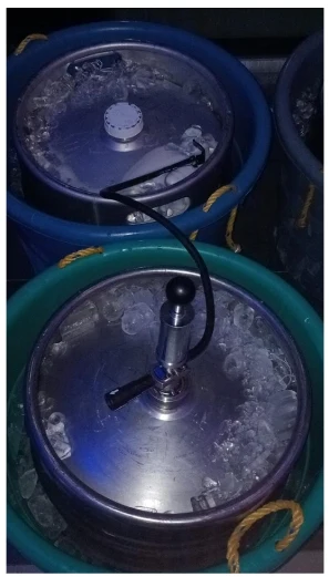 Barriles de cerveza en cubetas con hielo y extractor listos para servir