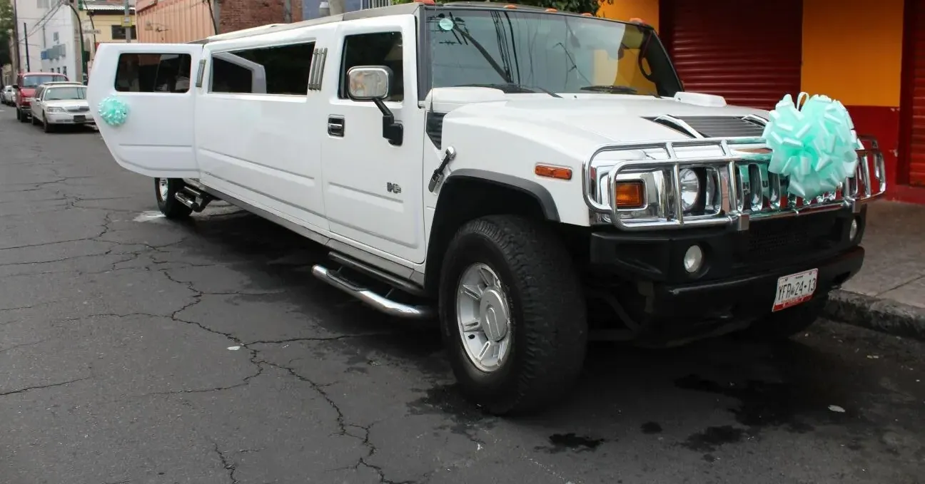Limusina Hummer blanca con moño turquesa y puerta abierta