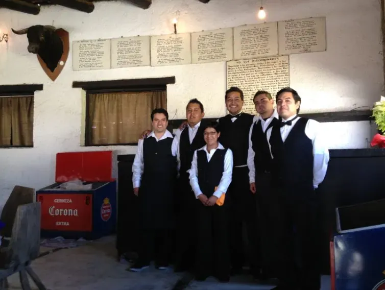 Equipo de meseros uniformados listos para servir en un evento