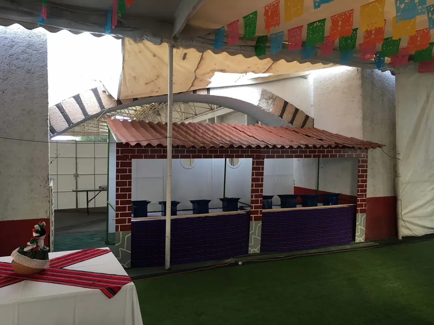 Estacion de comida con barra decorada con papel picado para taquiza en evento